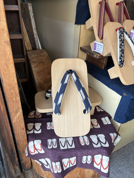 Close view of blue-and-white straps attached to a pale wooden geta base.