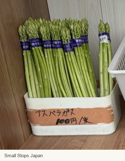 Asparagus bundles above a label showing 100 yen per bundle.