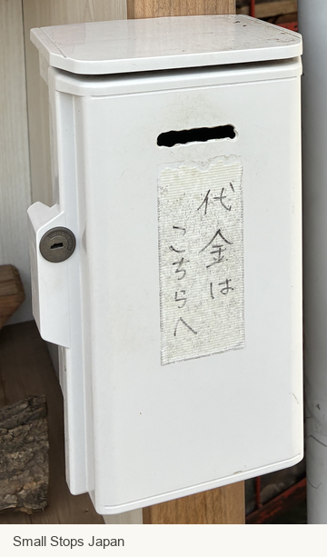 A white payment box with a slot and a Japanese label meaning Payment here.