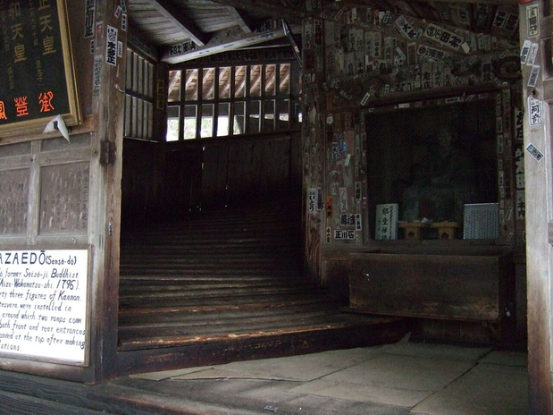 The entrance to Sazaedo showing a wooden passage sloping upward behind the doorway.