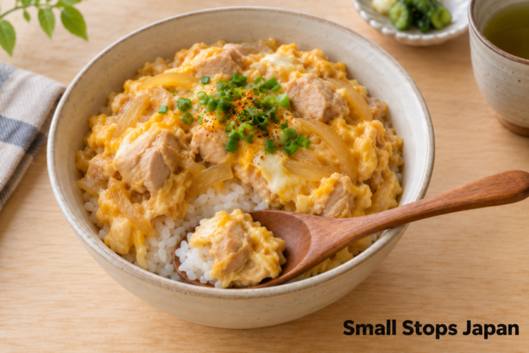 White rice is visible beneath an opening in a chicken-and-egg topping.